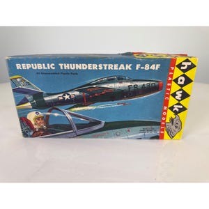 May include: A rectangular cardboard box for a Hawk Models Republic Thunderstreak F-84F model kit. The box features a blue background with an illustration of a silver jet fighter in flight, a pilot in a cockpit, and the text 43 Unassembled Plastic Parts.