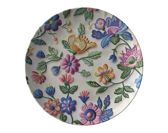 May include: A white ceramic plate with a floral design. The flowers are in shades of pink, blue, yellow, and green. The plate has a raised edge.