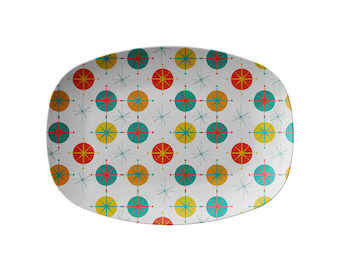 May include: A white oval serving platter with a mid-century modern pattern of red, yellow, and teal circles and stars.