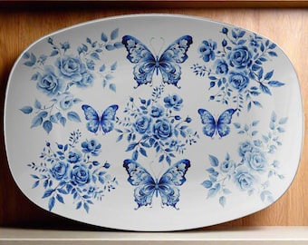 May include: White oval serving platter with a blue and white floral design featuring butterflies. The platter has a white background with blue flowers and butterflies.