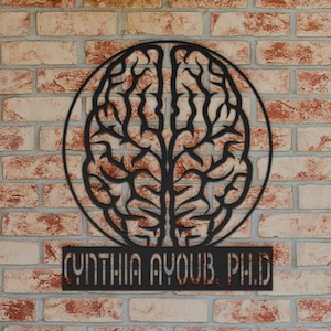 May include: Black metal wall art featuring a brain outline with the text "CYNTHIA AYOUB, PHD" below.