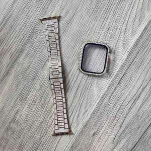 Puede incluir: Una correa de reloj de metal en tono oro rosa y una carcasa rectangular a juego, ambas totalmente incrustadas con peque&ntilde;os cristales transparentes. La correa presenta un dise&ntilde;o de eslabones y la carcasa tiene un marco interior negro.