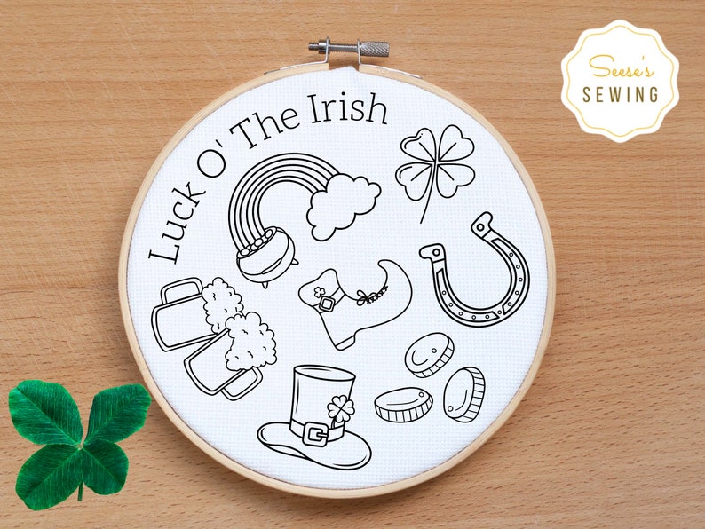 May include: A white embroidery hoop with the text "Luck O' The Irish" and various Irish-themed illustrations, including a pot of gold, a four-leaf clover, a horseshoe, a leprechaun's hat, and a pint of beer.
