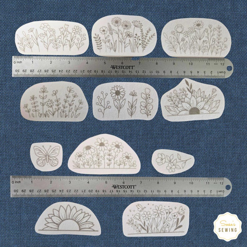 K&ouml;nnte beinhalten: Eine Sammlung von Stoffflicken mit floralen Motiven in verschiedenen Formen. Jeder Flicken zeigt ein anderes botanisches Design, darunter Blumen, Bl&auml;tter und ein Schmetterling, alles in einer neutralen Farbe. Ein Lineal liegt zur Gr&ouml;&szlig;enbestimmung &uuml;ber den Flicken.