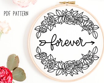 Puede incluir: Aro de bordado en blanco y negro con una corona de flores y la palabra "forever" con una flecha apuntando hacia la derecha.