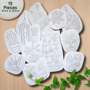 May include: A set of 13 white fabric pieces featuring gray line art illustrations of various potted plants and hanging planters, with the text 13 Pieces Stick & Stitch printed in the upper left corner on a circular embroidery hoop.