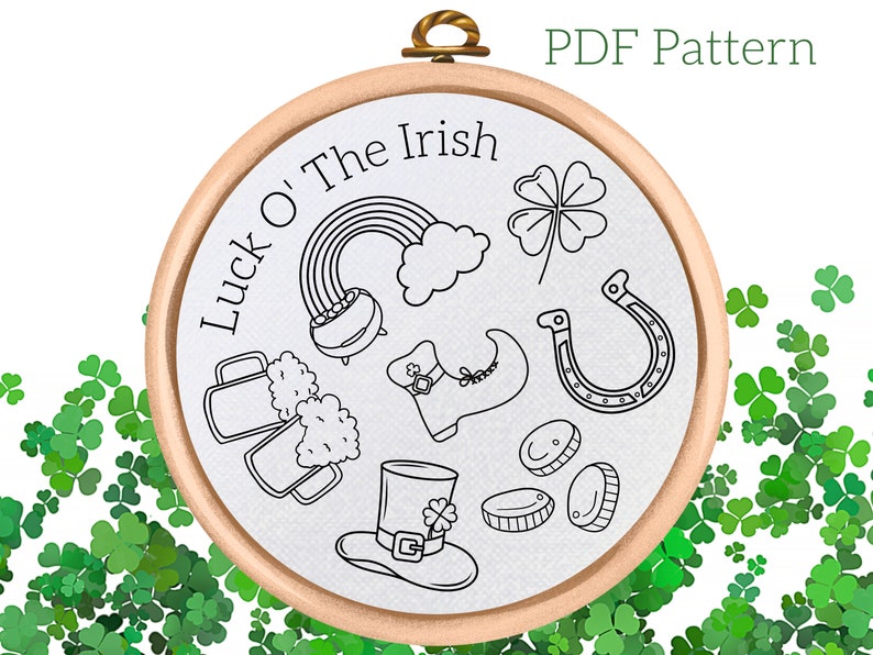 May include: A black and white embroidery pattern for a hoop art project. The design features Irish symbols such as a pot of gold, a rainbow, a horseshoe, a shamrock, a beer stein, a leprechaun's shoe, and a leprechaun's hat. The text "Luck o' The Irish" is written in a circle around the design.