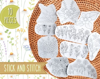 May include: Ten pieces of floral embroidery patterns on white paper with the text "Stick and Stitch" on a brown woven background.