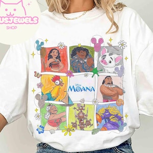 Pu&ograve; includere: T-shirt bianca con una grafica colorata dei personaggi del film Disney Moana. Il design include illustrazioni di Moana, Maui, Hei Hei, Pua e altri, disposti in un motivo a griglia. &Egrave; presente anche la parola "Moana".