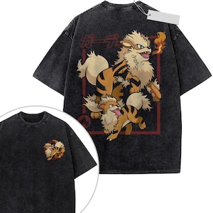 May include: A charcoal gray acid-wash t-shirt featuring a large graphic on the back of two orange and black striped canine creatures with fluffy fur and flames, accompanied by Japanese text. A smaller version of the same graphic is on the front.