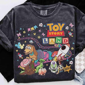 May include: A white ceramic mug with a black handle and the text "But First, Coffee" in a bold, black font. The mug is set against a blurred background, suggesting a cosy setting.