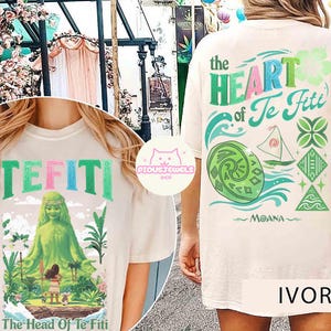 May include: Ivory-colored t-shirt featuring the text "TEFITI" in colorful letters. The front graphic depicts a green figure and the text "The Head Of Te Fiti". The back of the shirt has the text "The Heart of Te Fiti" and a Moana-themed design.