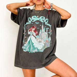 Op de afbeelding: Een witte keramische mok met een zwart handvat en de tekst "But First, Coffee" in een zwarte, handgeschreven lettertype. De mok staat op een wit oppervlak.