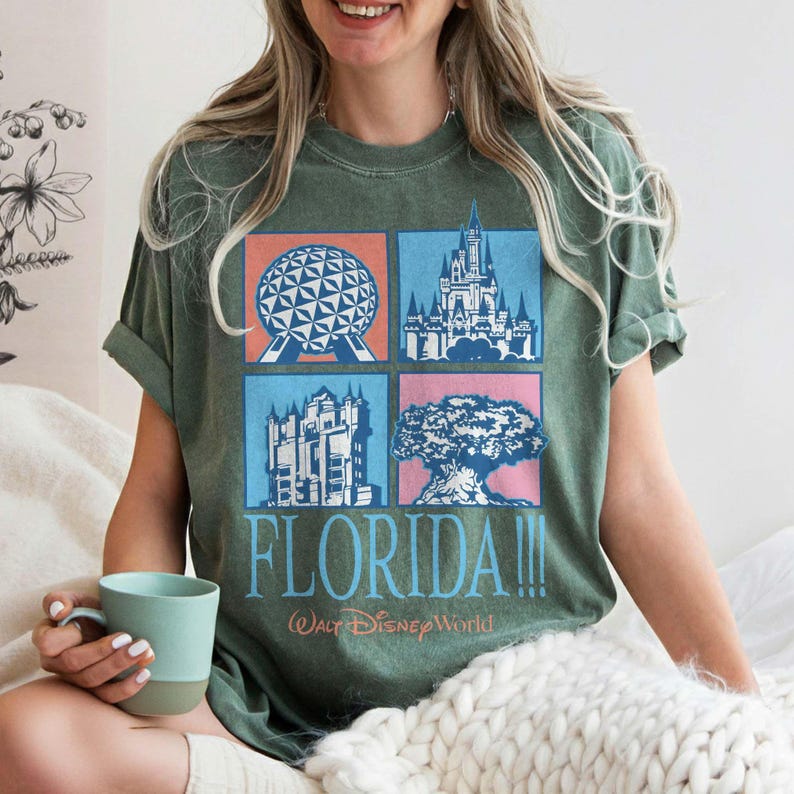 May include: Green t-shirt featuring four iconic Florida landmarks in square boxes: a geodesic sphere, a castle, a building, and a tree. The word "FLORIDA!!!" is printed below, with "Walt Disney World" underneath.