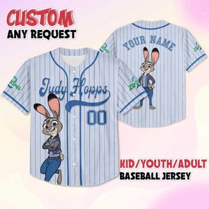 May include: Light blue baseball jersey with vertical white stripes, featuring the name "Judy Hopps" and the number "00". The jersey has a cartoon image of Judy Hopps. The text "CUSTOM ANY REQUEST" and "KID/YOUTH/ADULT BASEBALL JERSEY" are also visible.