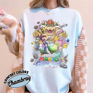 K&ouml;nnte beinhalten: Eine wei&szlig;e Keramik-Tasse mit schwarzem Henkel und dem Text "But First, Coffee" in handschriftlichem Stil. Die Tasse steht auf einer wei&szlig;en Oberfl&auml;che. Die Tasse ist 10 cm hoch.