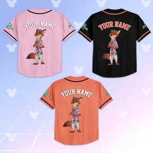 Puede incluir: Tres camisetas de b&eacute;isbol en rosa, negro y naranja. Cada camiseta presenta un personaje de zorro de dibujos animados y el texto "YOUR NAME" en la espalda. Las mangas tienen rayas contrastantes y el logo de Zootopia.