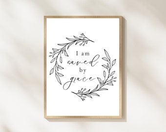 May include: A black and white printable wall art print with a floral wreath and the text "I am saved by grace".