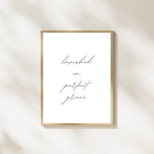 May include: A framed print with the text "lavished in perfect grace" written in cursive script.