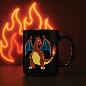 Könnte beinhalten: Schwarze Keramiktasse mit einem neonorangen und blauen Bild eines Charizard-Pokémon. Die Tasse hat einen weißen Henkel.