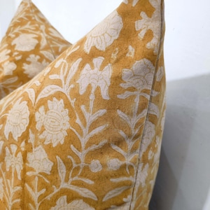 May include: Two mustard yellow pillowcases with a white floral pattern. The pillowcases are made of a soft, textured fabric.