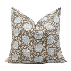 May include: A brown and white floral patterned pillow cover. The pillow cover has a white background with brown floral designs.