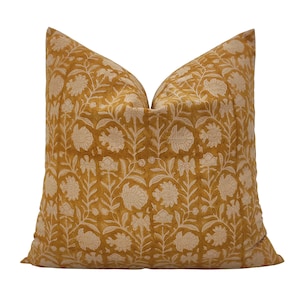 Peut inclure: Un oreiller jaune moutarde avec un motif floral blanc. L'oreiller est fait d'un tissu doux, semblable au lin.