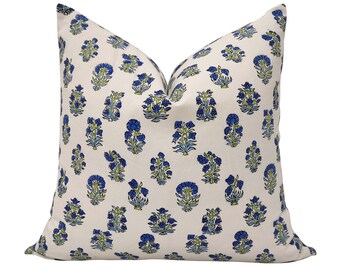 May include: A white pillow cover with a blue and green floral pattern. The pillow cover features a repeating pattern of small blue flowers with green leaves.
