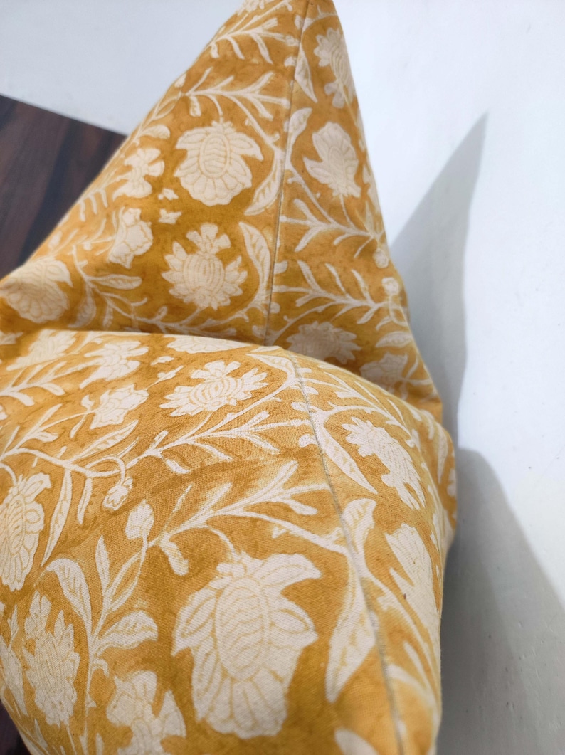 May include: A yellow cushion with a white floral pattern. The cushion is made of a soft, comfortable fabric and has a subtle sheen.