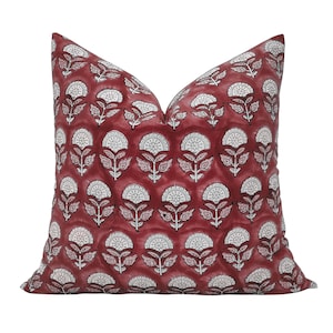 Pode incluir: Uma almofada quadrada de algodão com um padrão floral vermelho e branco.