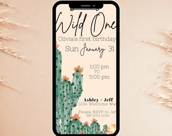 May include: A digital download invitation for a first birthday party with a cactus theme. The invitation features a green cactus with pink flowers and the text "Wild One" in black cursive. The invitation also includes the date "Sun January 31", the time "1:00 pm to 5:00 pm", and the names "Ashley + Jeff".