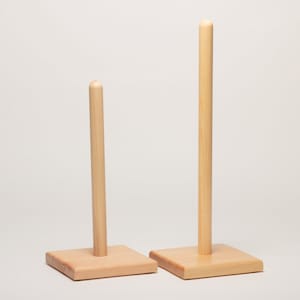 May include: Two wooden paper towel holders, one taller than the other, with square bases.