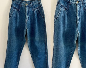 May include: A pair of blue denim jeans with a high waist and pleats in the front. The jeans have a straight leg and are made of a soft, comfortable fabric.