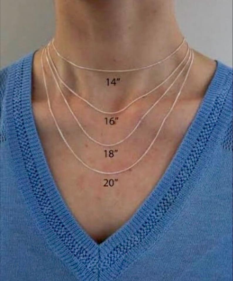 Pode incluir: Quatro colares de prata de diferentes comprimentos, exibidos no peito de uma pessoa. Os colares s&atilde;o rotulados com seus comprimentos: 35,5 cm, 40,6 cm, 45,7 cm e 50,8 cm. A pessoa est&aacute; vestindo um su&eacute;ter azul.