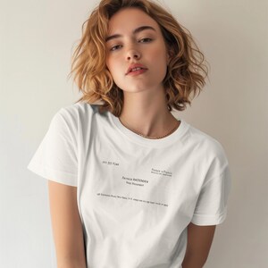 May include: A white short-sleeved t-shirt featuring black printed text that mimics a business card. The text includes the name Patrick Bateman, the title Vice President, the company Pierce & Pierce, and an address in New York, New York.