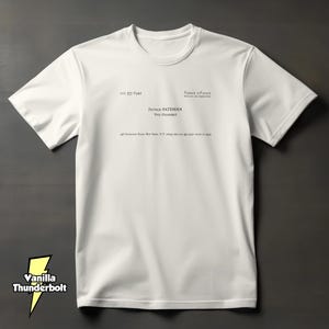 May include: A white short-sleeved t-shirt featuring a black printed business card design on the chest. The text reads Pierce & Pierce, Patrick Bateman, Vice President, along with a New York address and phone number, mimicking a professional card.