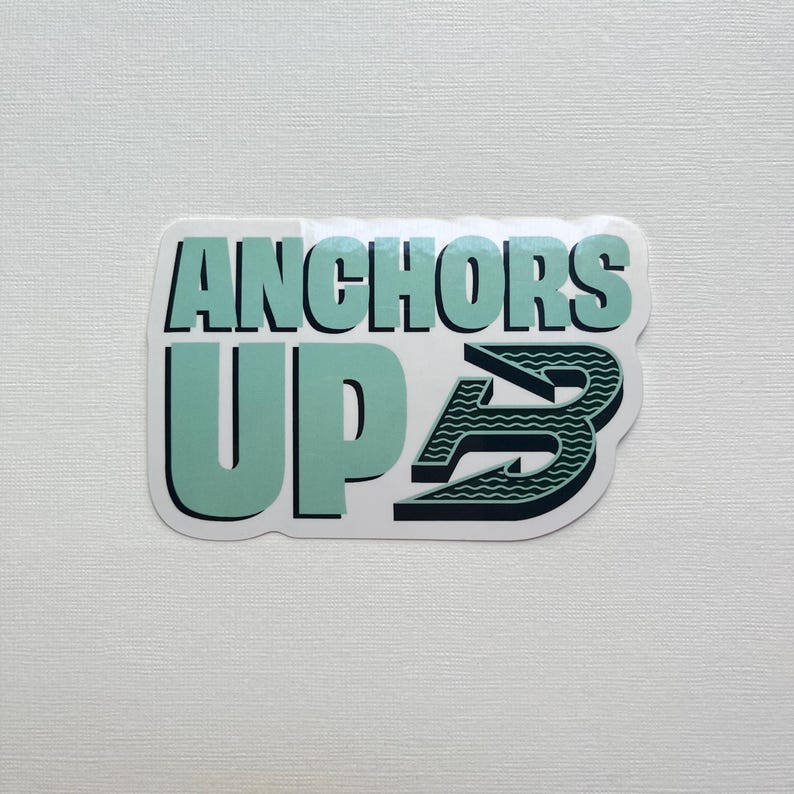 May include: A rectangular sticker with the words "ANCHORS UP" in a teal and black color scheme. The "B" in "UP" is stylized with a wave pattern. The sticker is on a white background.