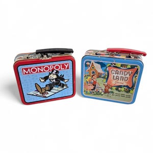 Peut inclure: Deux boîtes à lunch en métal vintage. L'une présente le logo Monopoly avec le personnage de l'homme Monopoly. L'autre boîte à lunch a un design de jeu Candy Land avec une maison en pain d'épices et des enfants. Les deux ont des poignées rouges et noires.