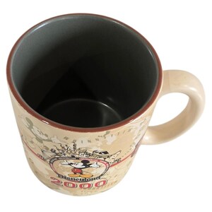Pode incluir: Caneca de cer&acirc;mica creme com um design de mapa e as palavras "Disneyland 2000" com Mickey Mouse. A caneca tem uma al&ccedil;a bege e um interior cinza escuro. A borda &eacute; marrom.