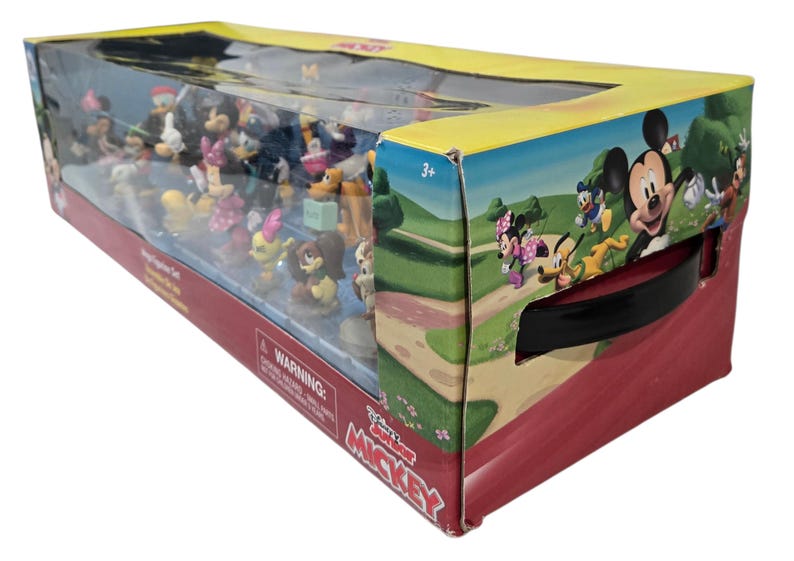 May include: A boxed set of Disney's Mickey Mouse Clubhouse figurines. The box is red and yellow with a clear plastic front, showcasing various character figures. The box art features Mickey, Minnie, Donald, and Goofy.
