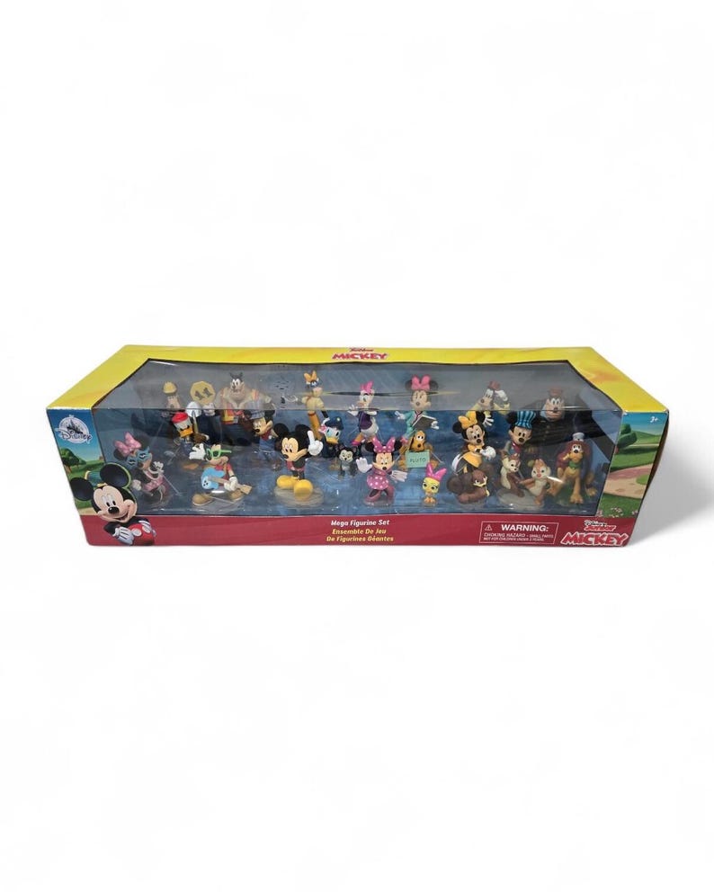 May include: A boxed set of Mickey Mouse figurines. The set includes various characters in different poses. The box has a yellow top and a clear front, with the Mickey Mouse logo on the side. The text "Mega Figurine Set" is visible.