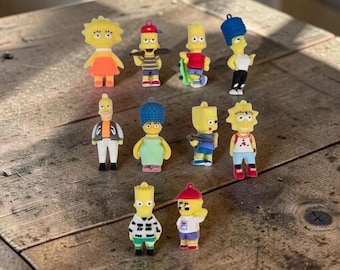 May include: A collection of ten small, colourful plastic character figurines representing various members of a cartoon family. Each figure features distinct clothing, accessories, and hairstyles, including hats, skateboards, and patterned shirts, arranged in three rows.