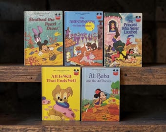 May include: Five vintage Walt Disney Productions storybooks featuring colorful illustrations. Titles include Sindbad the Pearl Diver, The Aristocats Get Into Mischief, The Princess Who Never Laughed, All Is Well That Ends Well, and Ali Baba and the 40 Thieves.