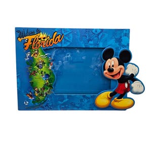 Op de afbeelding: Blauwe fotolijst met Mickey Mouse en een kaart van Florida. De lijst heeft de woorden "Welcome to Florida" in geel en oranje. Mickey Mouse draagt zijn klassieke outfit.