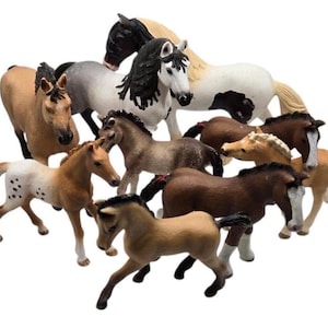 Puede incluir: Un juego de tres tazas de cerámica con un esmalte moteado de color crema. Cada taza presenta un diseño pintado a mano diferente: una hoja azul y verde, una flor amarilla y una baya roja. Las tazas tienen un diseño simple y moderno.