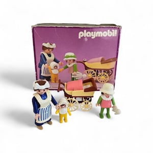Puede incluir: Un juego de Playmobil vintage con figuras de adultos y niños, junto con dos cochecitos. Las figuras visten de azul, blanco, amarillo, verde y rosa. El juego se presenta en una caja morada con el logotipo de Playmobil.