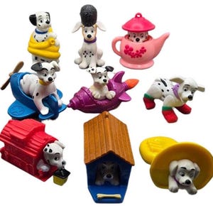 Könnte beinhalten: Eine Sammlung von Dalmatiner-Hundefiguren in verschiedenen Posen und Umgebungen. Die Figuren zeigen einen Hund in einem Flugzeug, einen Hund in einer Rakete und einen Hund in einer Teekanne. Die Figuren sind in verschiedenen Farben gehalten, darunter Rot, Blau und Gelb.