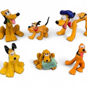 May include: A collection of six Pluto figurines in various poses. The figures are primarily yellow with black accents, featuring Pluto's signature floppy ears and expressive faces. One figure holds a block with the name "PLUTO".