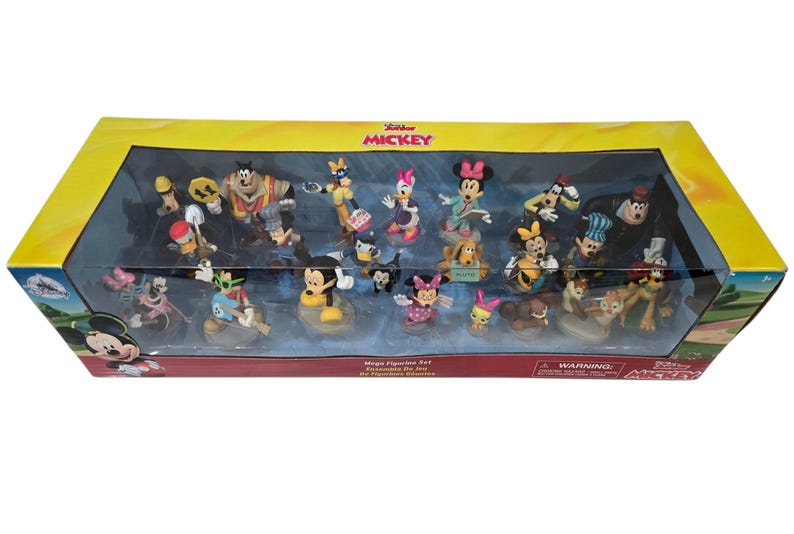 May include: A boxed set of Disney figurines featuring Mickey Mouse and friends. The set includes various characters in colorful outfits, displayed on individual bases. The packaging is a yellow and clear plastic box with the words "Junior Mickey" on the top.