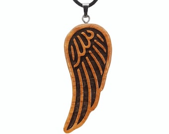 May include: A wooden pendant necklace featuring a carved wing design. The pendant is a light brown color with dark brown accents, suspended from a black cord. The wing design is detailed and intricate.